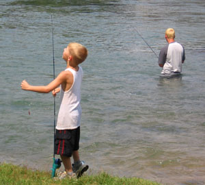 Two boys fish below the dam.